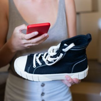 a person holding a shoe and a smartphone